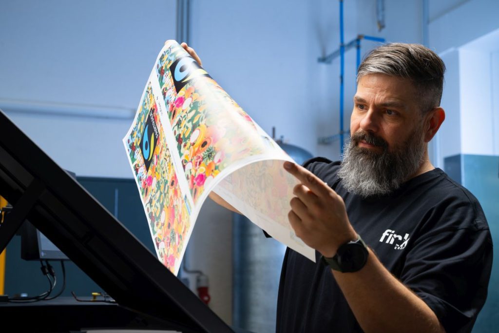 A man holding up printing from the Jet Press 750S HSM printer