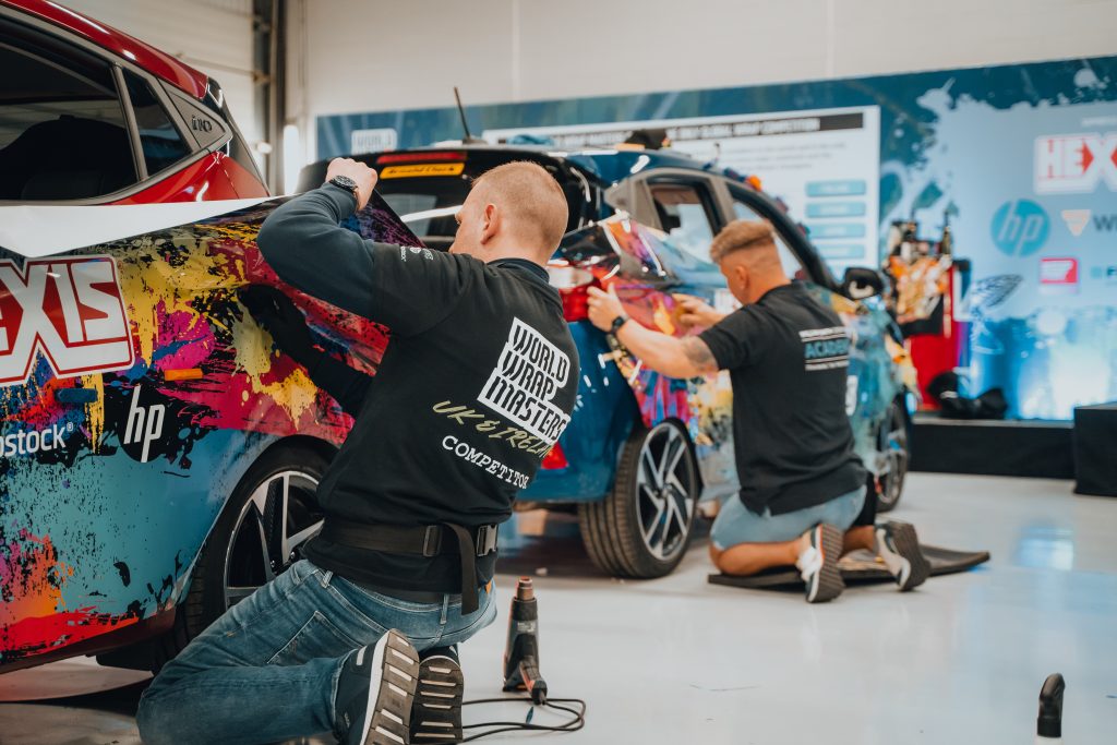 Men wrapping cars at WrapFest 2024