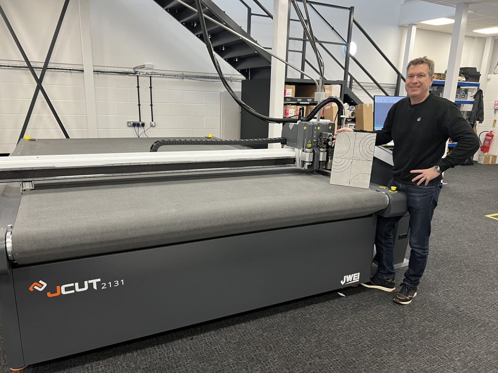 The JWEI JCUT 2131 cutting machine next to an employee at XSTONE UK